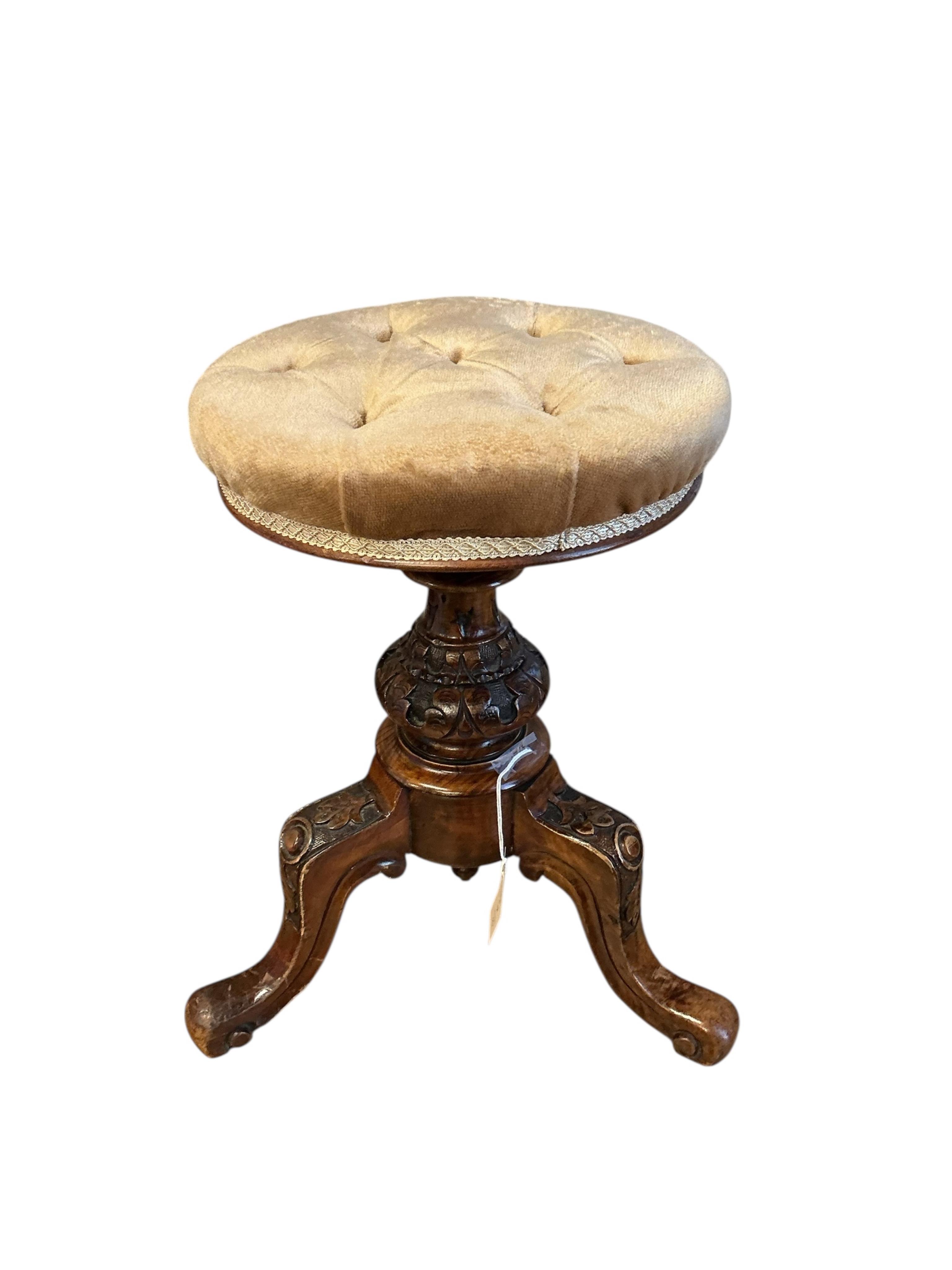A Victorian walnut revolving piano stool